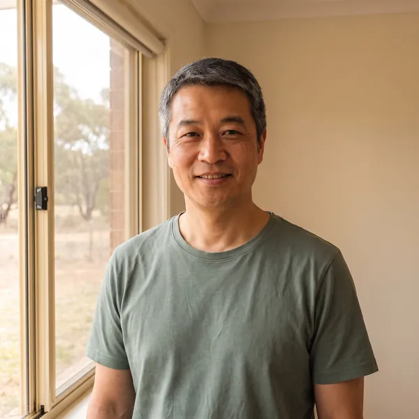 Daniel Chen, smiling, standing by a window in the clinic.