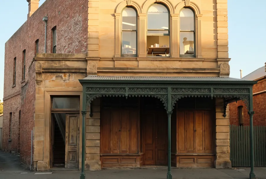 A two-storey Victorian building on View Street with sandstone arched windows upstairs and a green cast-iron verandah over timber doors.