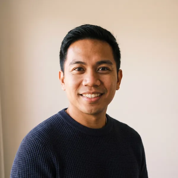 Paolo Santos, smiling, in a navy jumper.