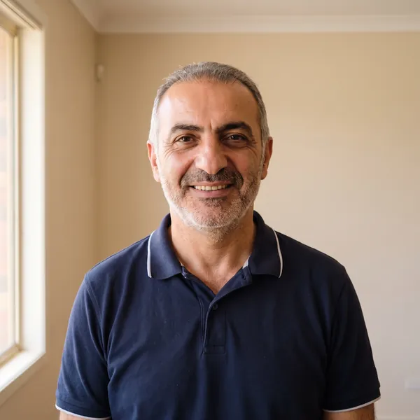 Theo Pappas, smiling, in a navy polo shirt.
